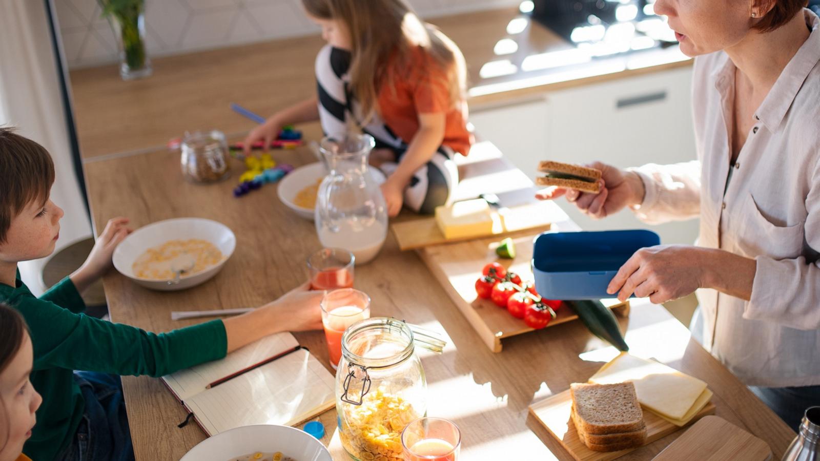 PHOTO: Mother of three little children preparing breakfast in kitchen at home.
