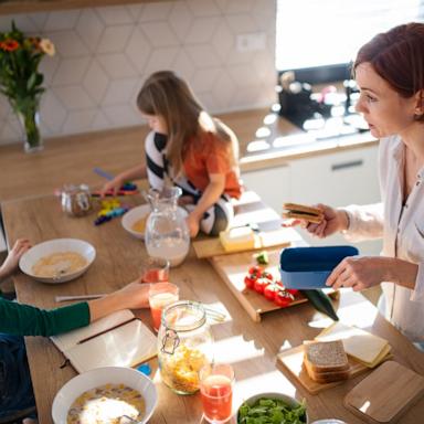 PHOTO: Mother of three little children preparing breakfast in kitchen at home.