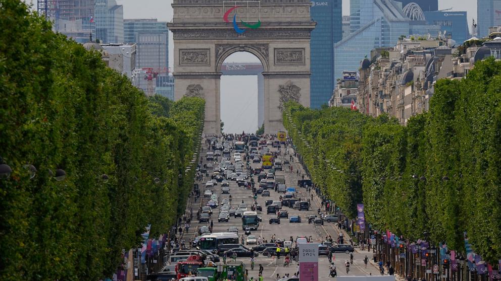 PHOTO: Pedestrians and traffic move along the Champs Elysees past the Arc de Triumph ahead of the 2024 Summer Olympics, July 25, 2024, in Paris.