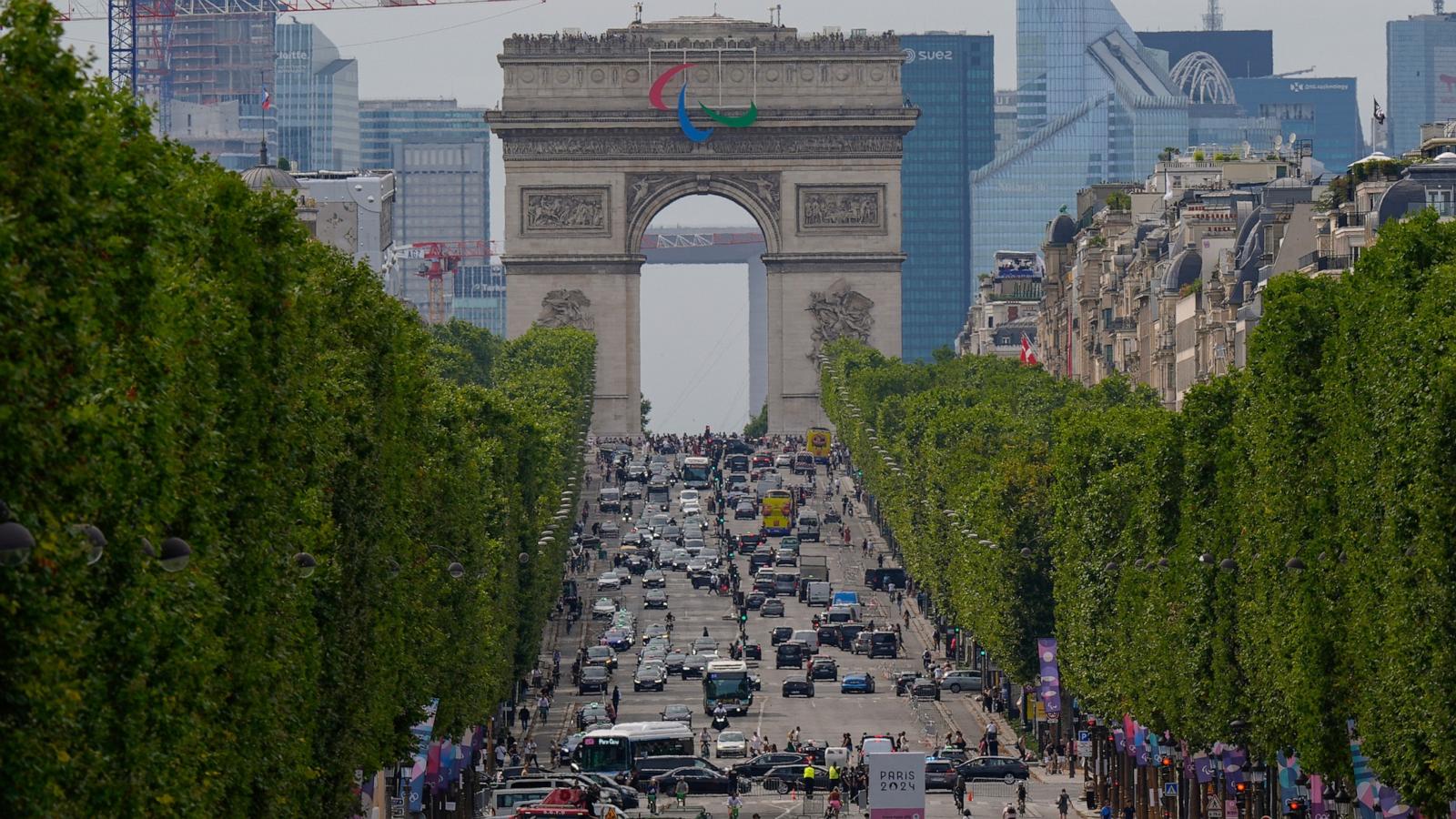 PHOTO: Pedestrians and traffic move along the Champs Elysees past the Arc de Triumph ahead of the 2024 Summer Olympics, July 25, 2024, in Paris.