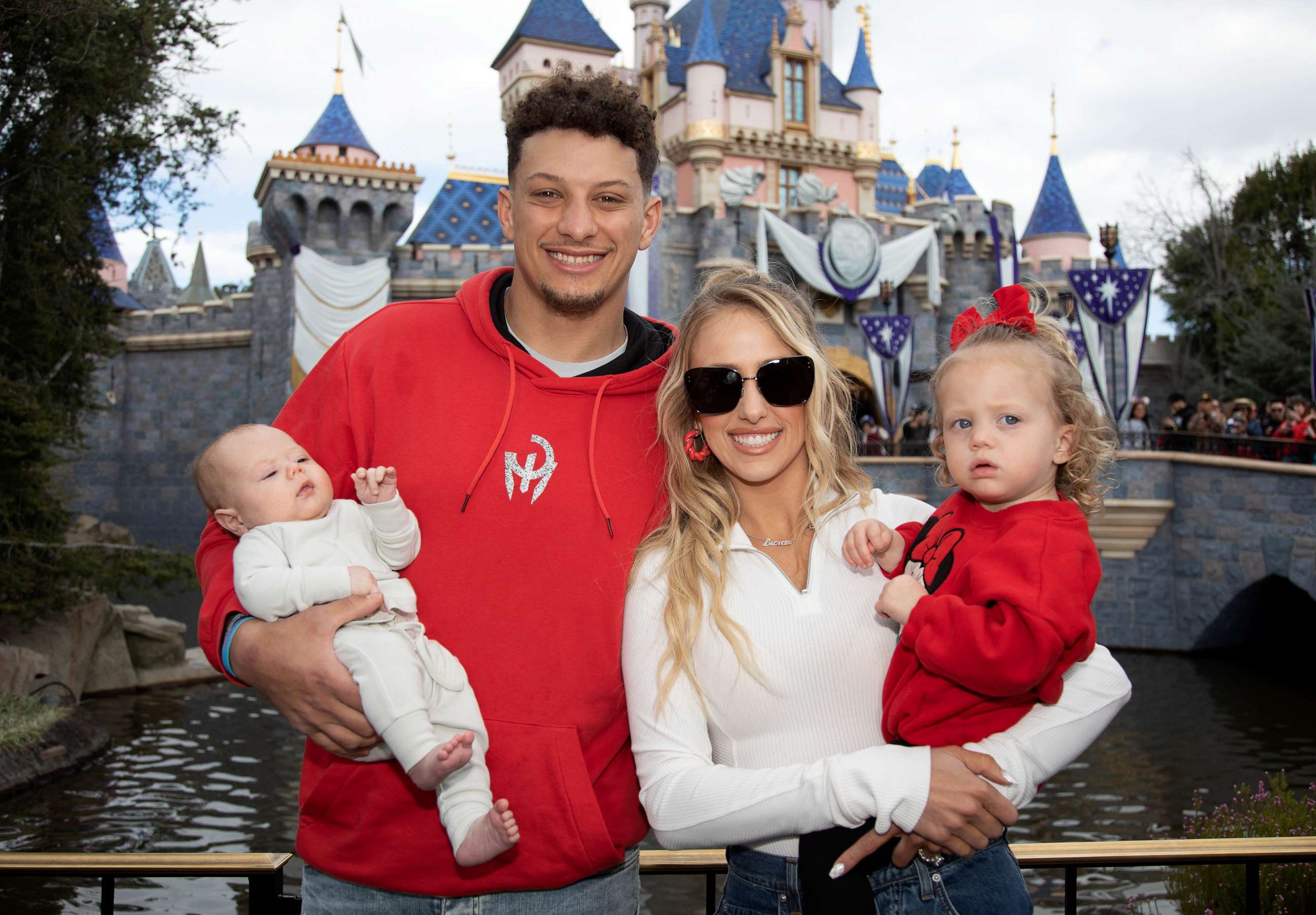 PHOTO: Patrick Mahomes of the Kansas City Chiefs and Brittney Mahomes pose with their children, Sterling, 1, and Bronze, 11 weeks old, in front of Sleeping Beauty Castle at Disneyland Park on February 13, 2023, in Anaheim, Calif.