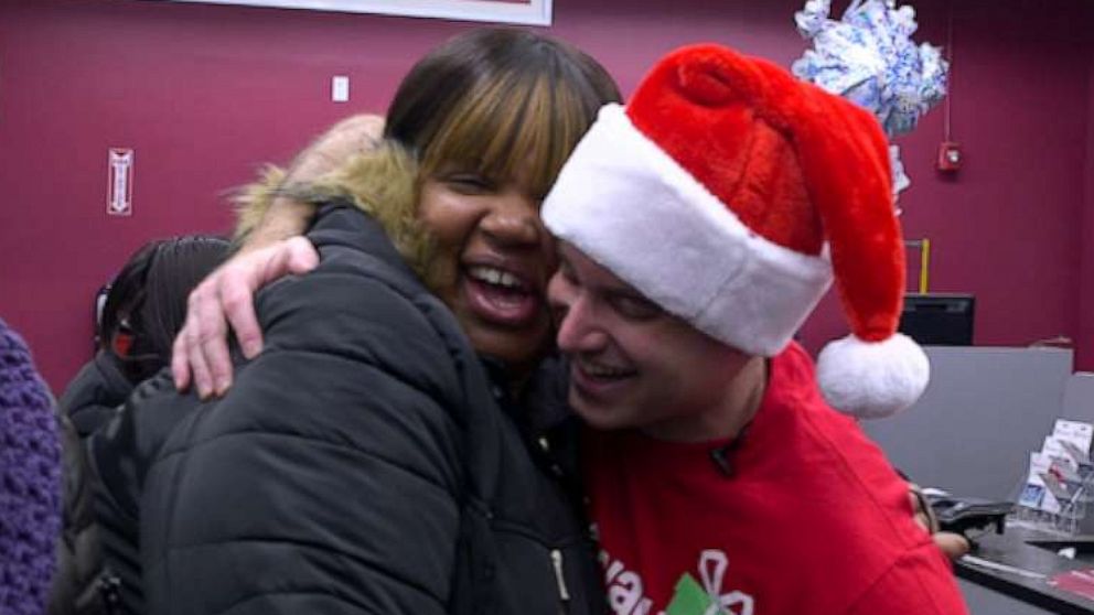 PHOTO: Pay Away the Layaway co-founder Ian Bel hugs a customer after announcing her layoffs were paid off.