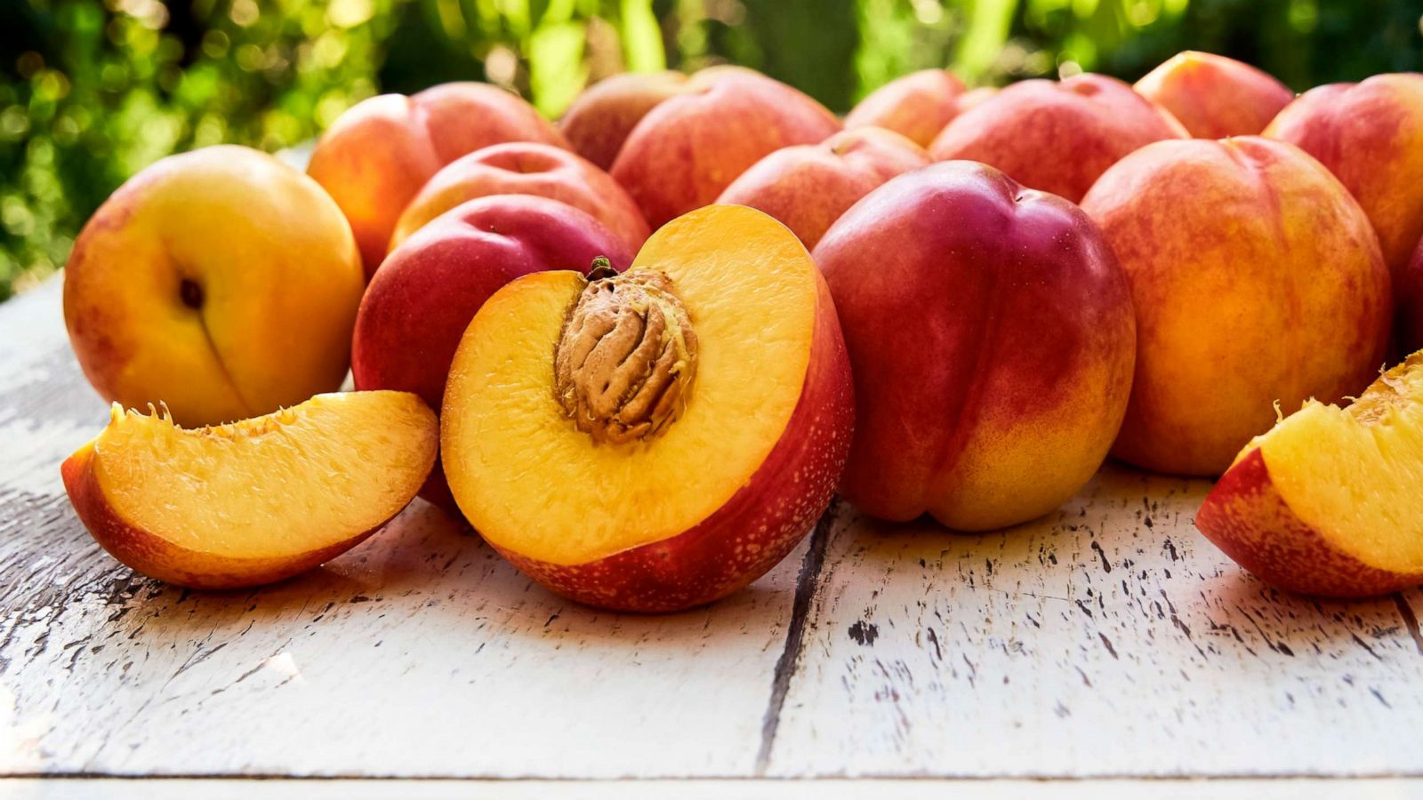 PHOTO: Ripe peaches with leaves on the old wooden table.