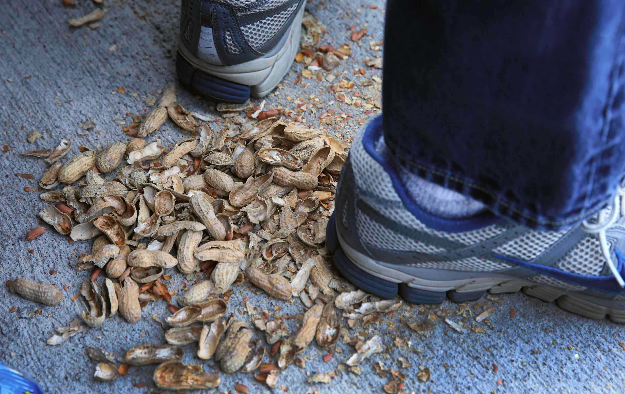 PHOTO: Empty peanut shells are seen beneath shoes during Opening Day at Fenway Park.