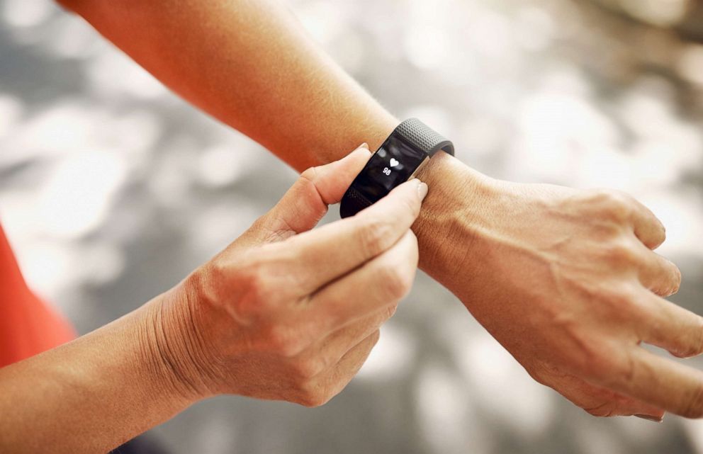 PHOTO: A woman looks at her pedometer in anundated stock photo. 