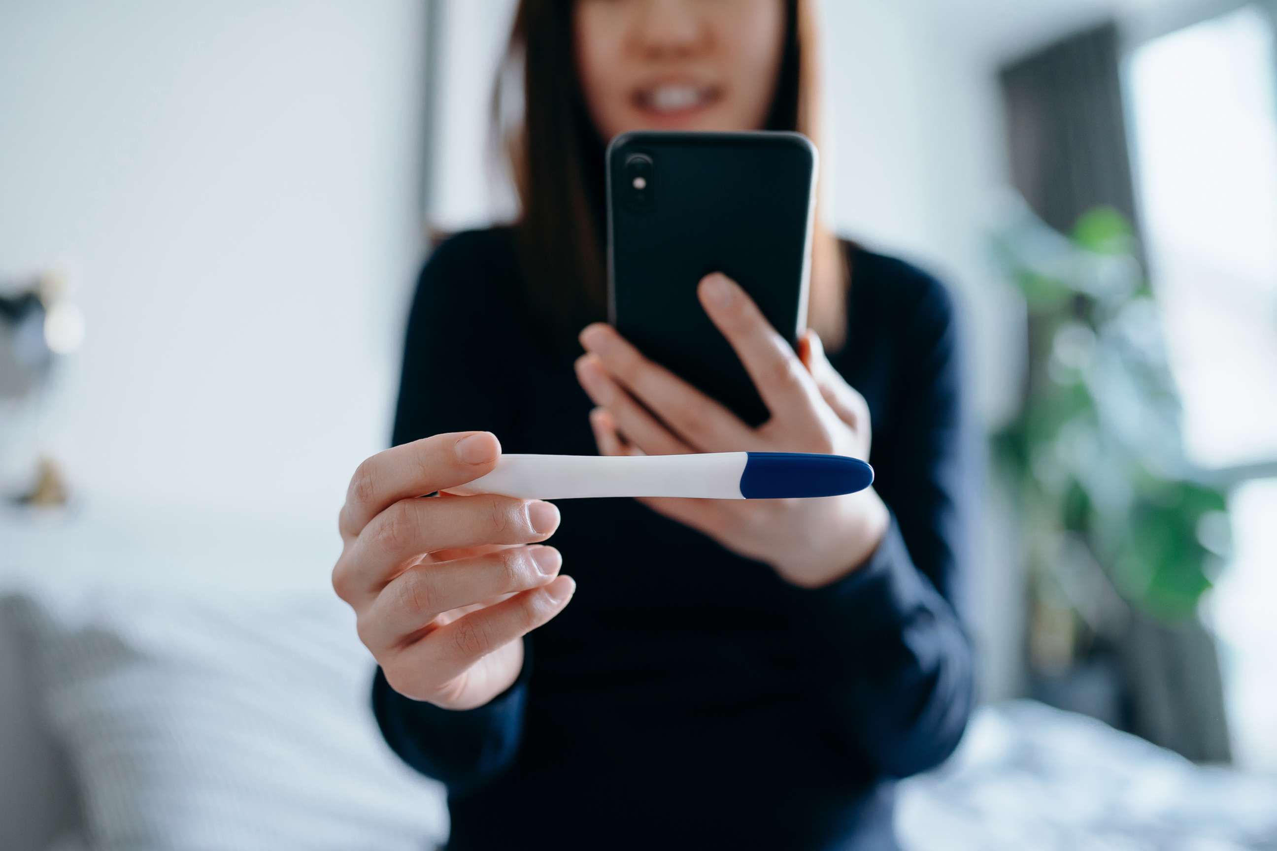PHOTO: A woman takes a photo of a pregnancy test with a smartphone in an undated stock photo. 