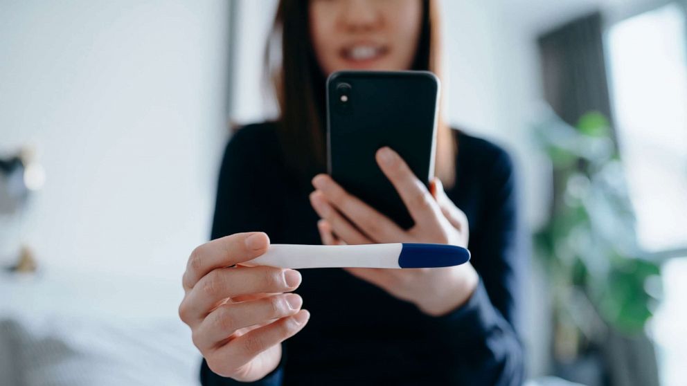 PHOTO: A woman takes a photo of a pregnancy test with a smartphone in an undated stock photo. 