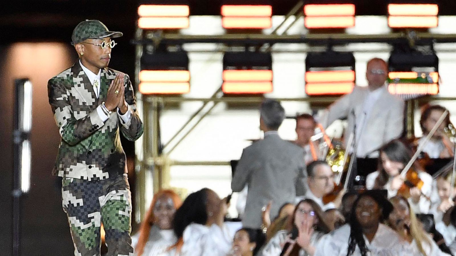 PHOTO: US Louis Vuitton' fashion designer and singer Pharrell Williams acknowledges the audience at the end of the Louis Vuitton Menswear Spring-Summer 2024 show as part of the Paris Fashion Week on the Pont Neuf, central Paris, on June 20, 2023.