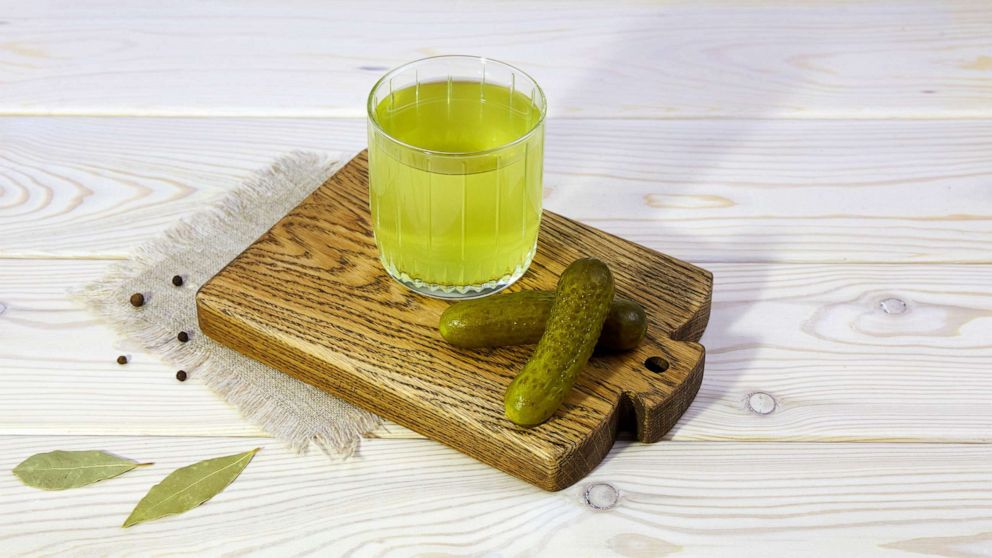 PHOTO: In an undated stock photo, pickle juice is seen in a glass next to two pickles.