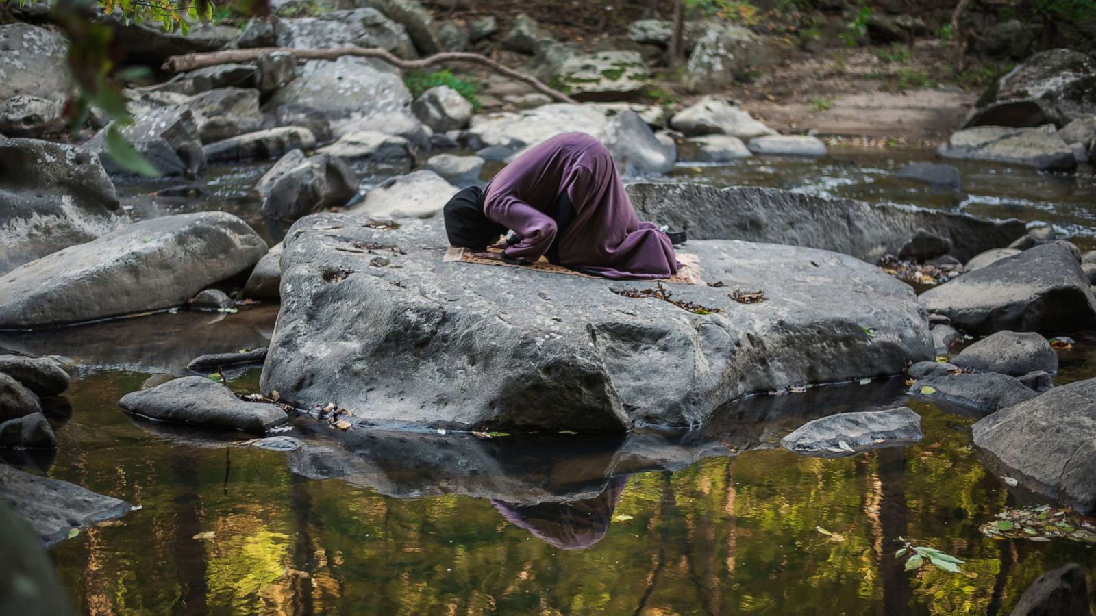 PHOTO: A woman prays on a flat rock in Rock Creek Park in Washington, D.C.