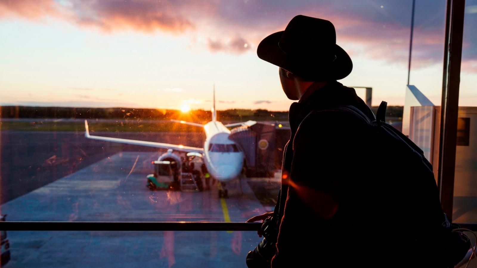 PHOTO: Stock photo of a person looking at a plane before take off.