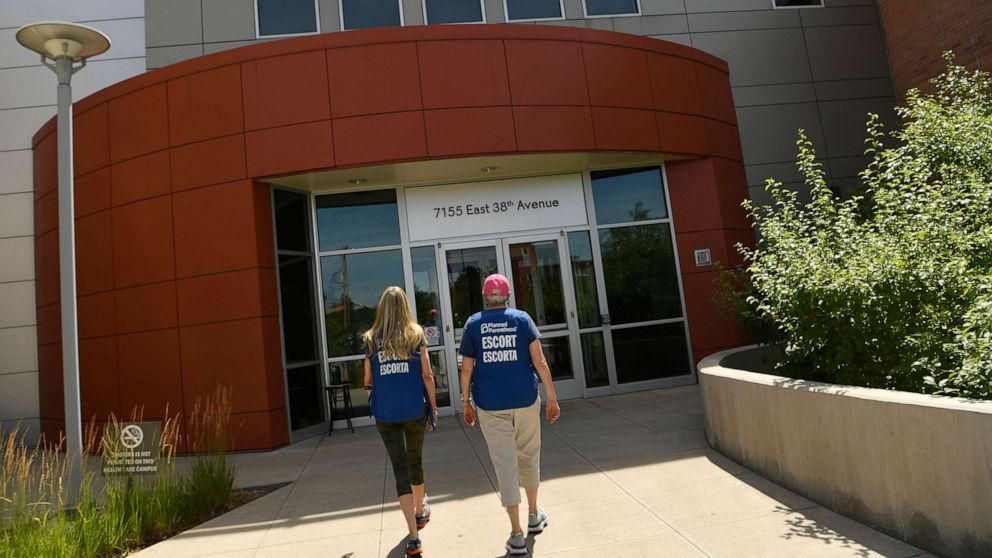 PHOTO: Volunteer escorts wait to assist incoming patients outside of the Planned Parenthood on July 18, 2019 in Denver.