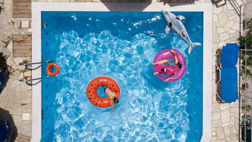 PHOTO: Children swim in a swimming pool.