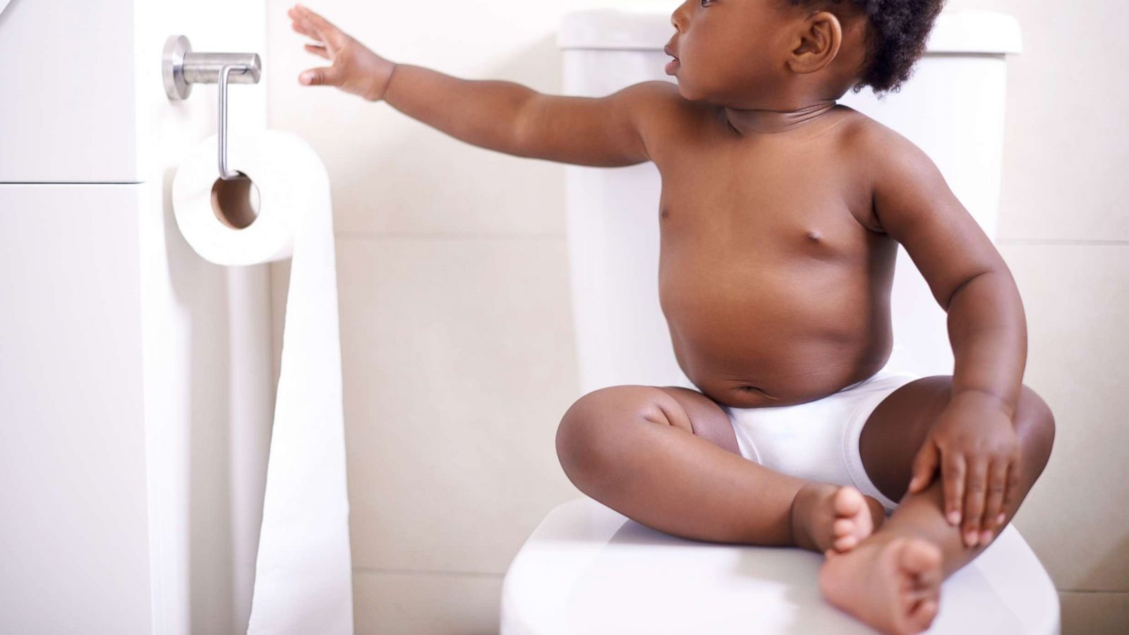 PHOTO: A toddler sitting on a toilet and reaches for toilet paper in this undated stock photo.