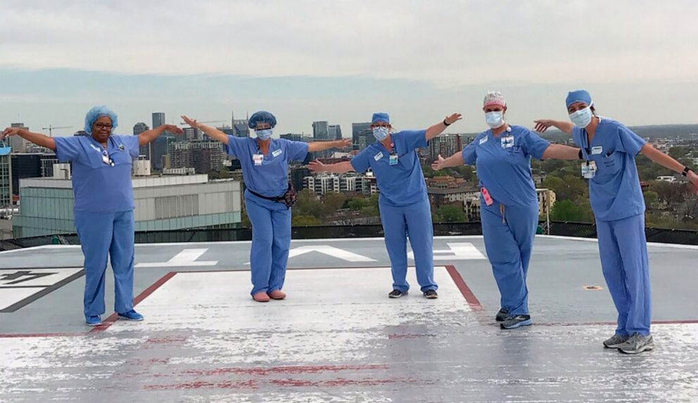 PHOTO: A group of nurses at the Vanderbilt University Medical Center in Nashville pray together on the hospital's helipad.