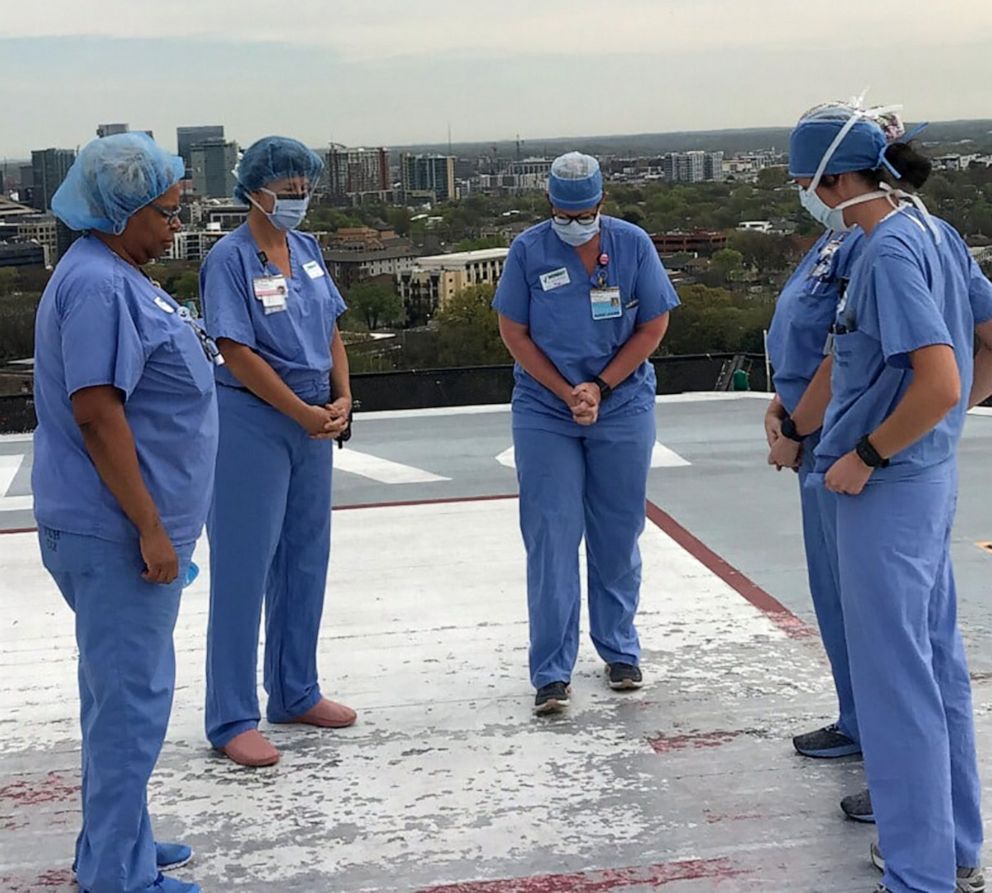 PHOTO: A group of nurses at the Vanderbilt University Medical Center in Nashville pray together on the hospitals helipad.