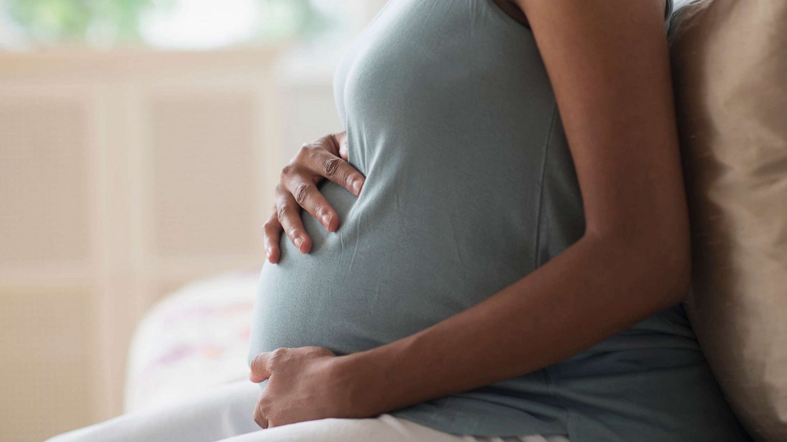 PHOTO: Pregnant African-American mother holds her stomach in an undated stock photo.