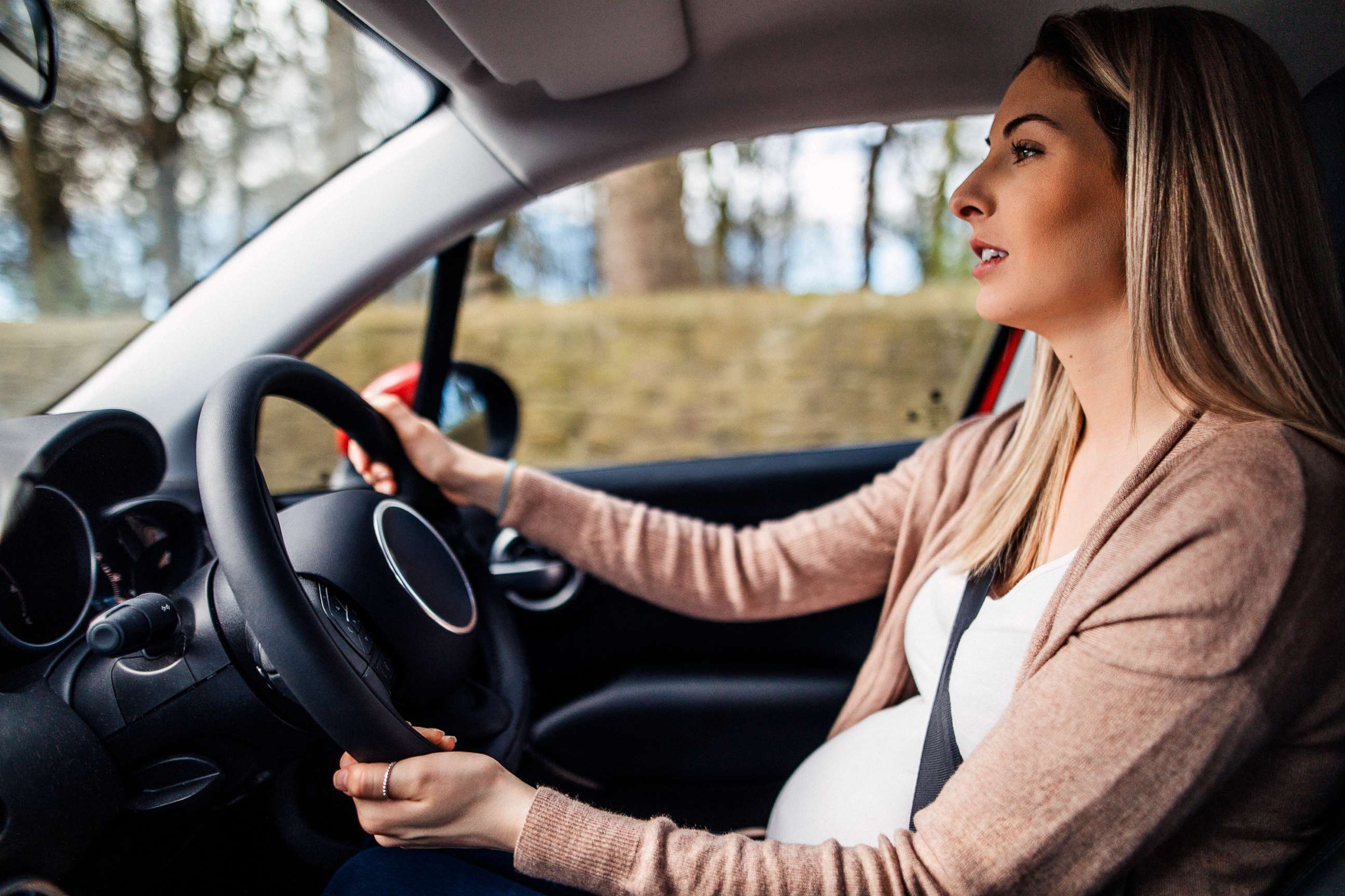 PHOTO: A young woman appears to be  driving a car while pregnant in this stock photo.