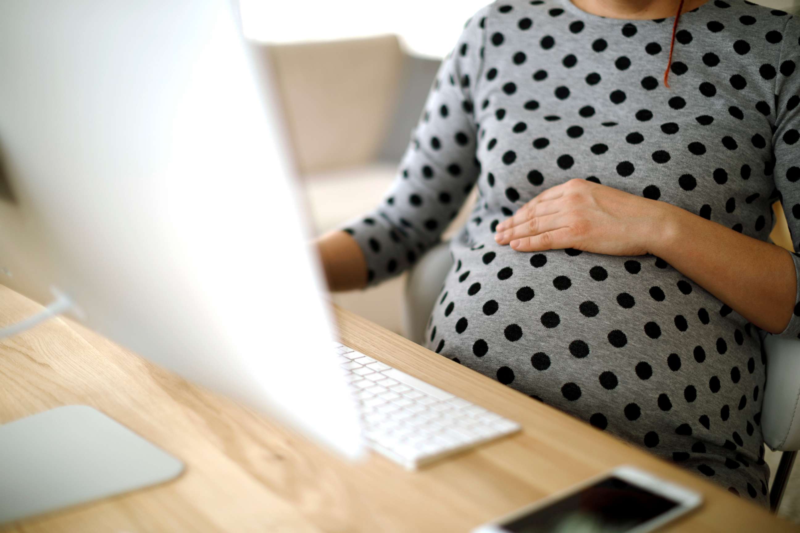 PHOTO: A pregnant woman works at an office.