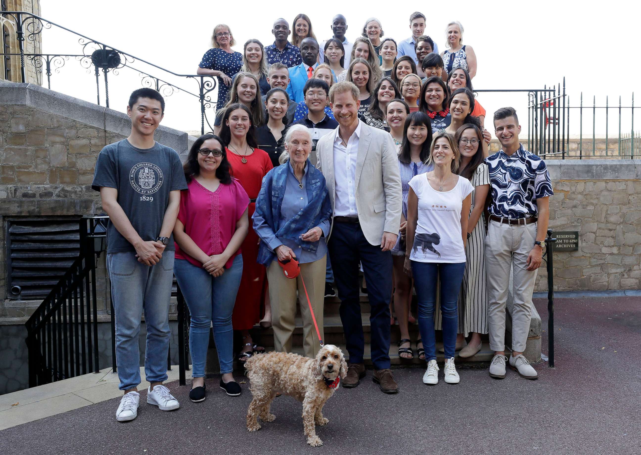 PHOTO: Prince Harry and Dr Jane Goodall pose for a photograph with Bella the Cockapoo and young people, as he attends Dr Jane Goodall's Roots & Shoots Global Leadership Meeting at St. George's House, Windsor Castle in England, July 23, 2019.