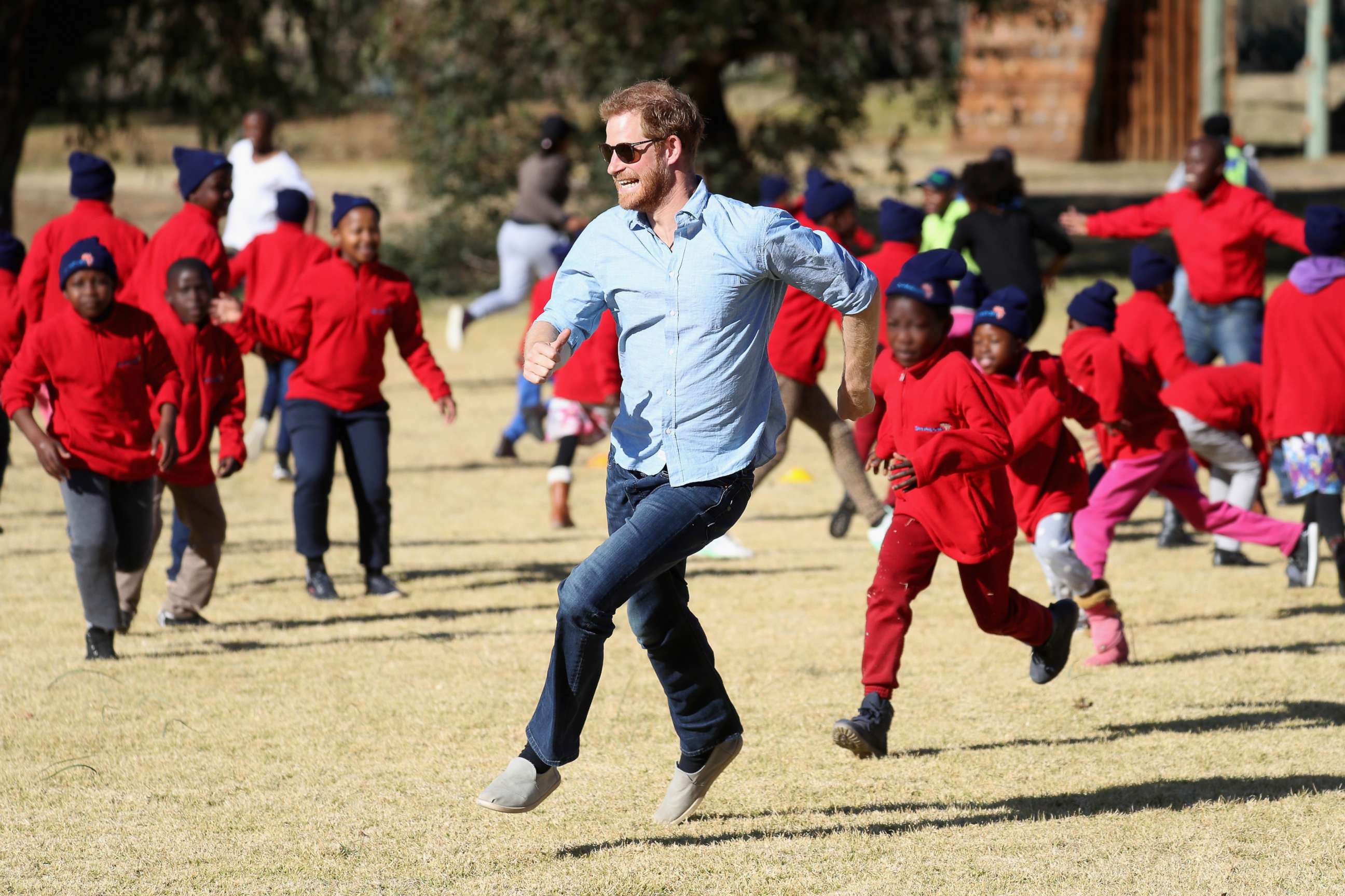 PHOTO: Prince Harry, Duke of Sussex and children run during Winter Camp at Sentebale's Mamohato Children's Centre on June 22, 2018 near Maseru, Lesotho.