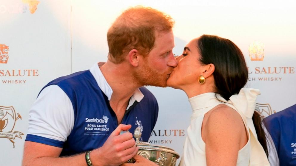 PHOTO: Britain's Prince Harry, left, and wife, Meghan Markle, Duchess of Sussex, kiss as she presents members of his polo team with the trophy for winning the Royal Salute Polo Challenge to Benefit Sentebale, on April 12, 2024, in Wellington, Fla.