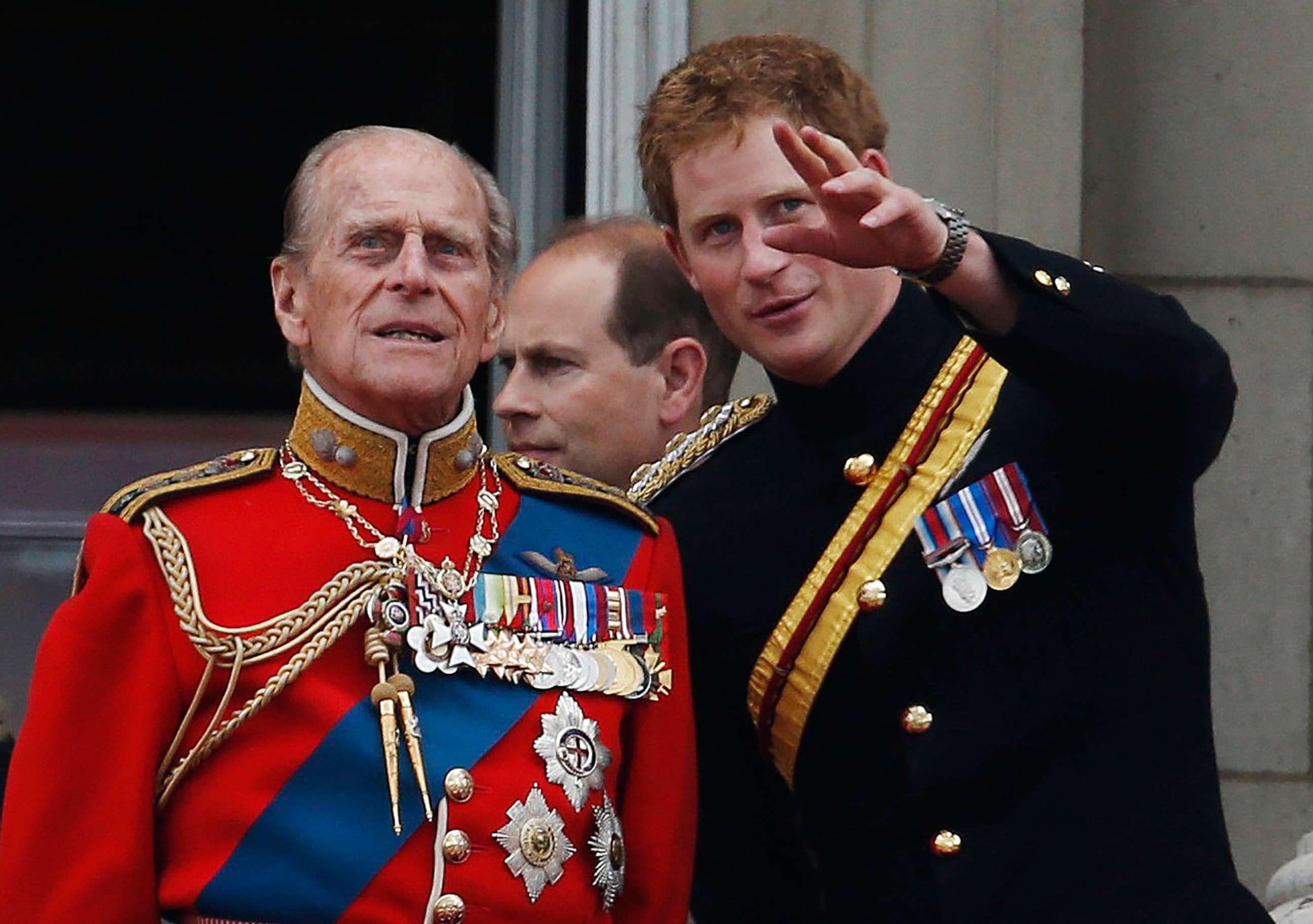 PHOTO: Britain's Prince Harry talks to Prince Philip as members of the Royal family appear on the balcony of Buckingham Palace, during the Trooping The Colour parade, in central London, June 14, 2014.