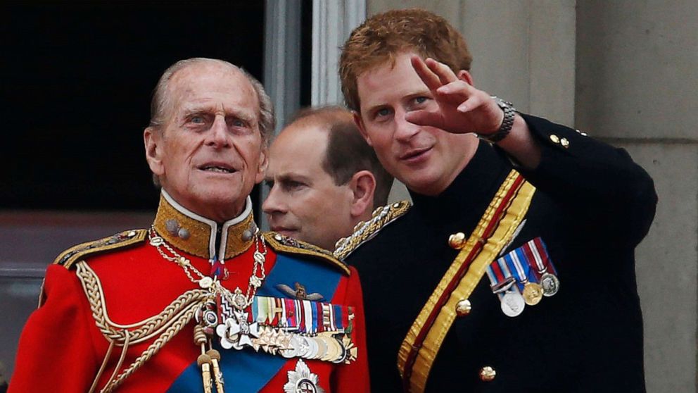 PHOTO: Britain's Prince Harry talks to Prince Philip as members of the Royal family appear on the balcony of Buckingham Palace, during the Trooping The Colour parade, in central London, June 14, 2014.