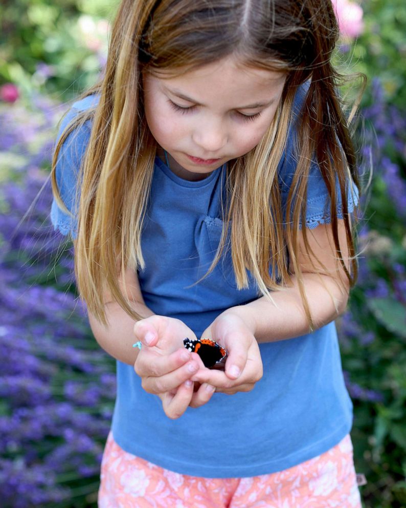 PHOTO: Britain's Princess Charlotte holds a red admiral butterfly in Norfolk, England, as part of the Big Butterfly Count initiative which is taking place across the UK.