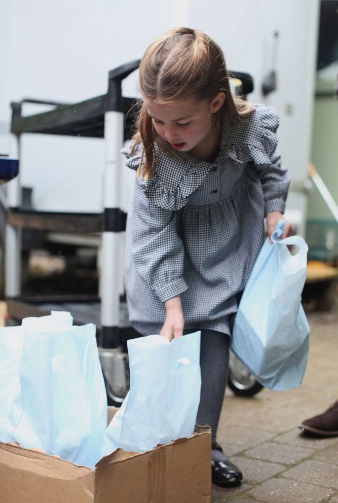 PHOTO: Princess Charlotte helps to pack up and deliver food packages for isolated pensioners in the local area along with her family.