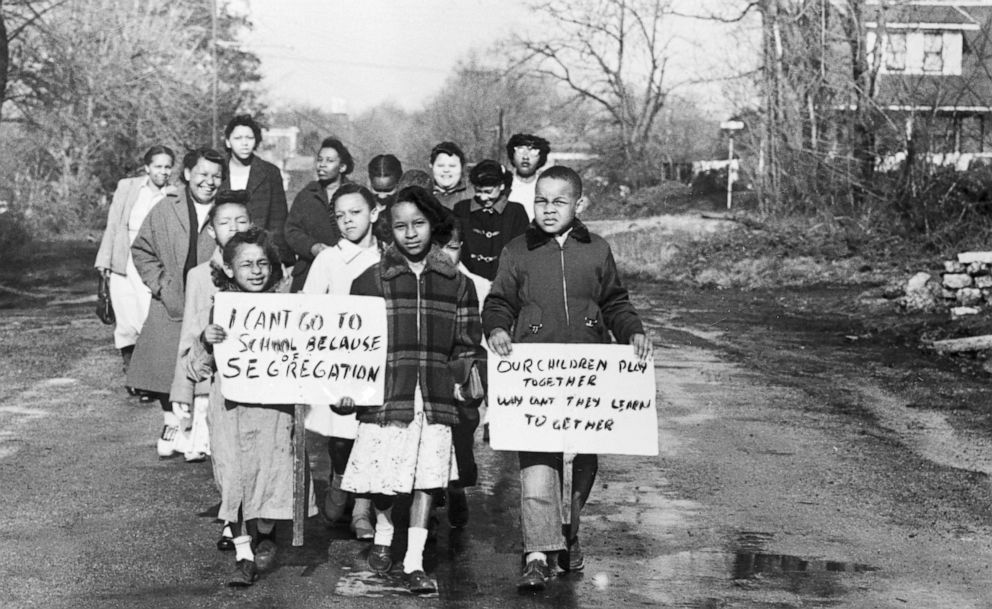 PHOTO: Sixteen Black children accompanied by 4 mothers carry signs demonstrating their feelings as they walk to Webster School in Hillsboro, Ohio, April 3, 1956.