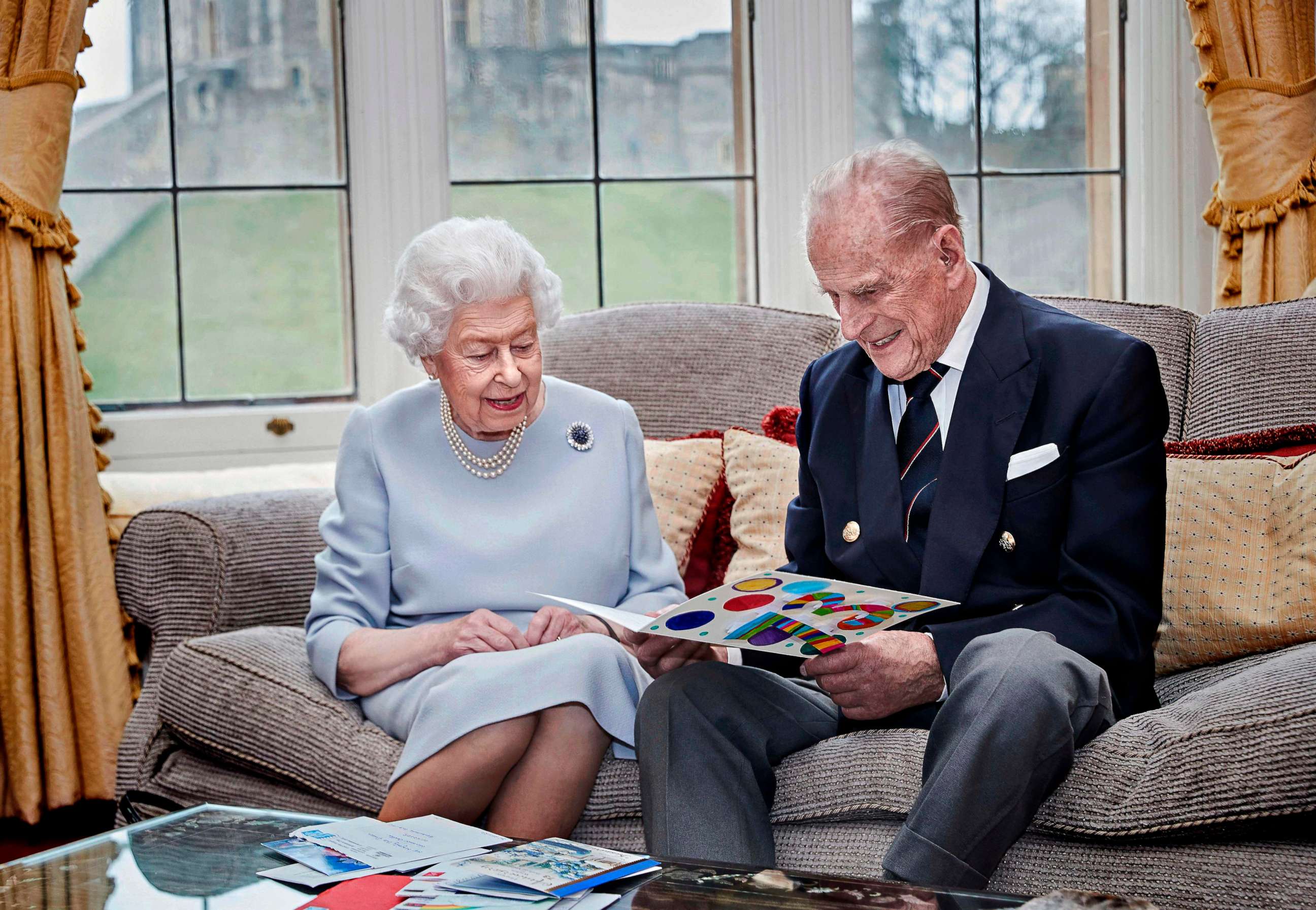 PHOTO: Britain's Queen Elizabeth and Prince Philip, Duke of Edinburgh look at their homemade wedding anniversary card in the Oak Room at Windsor Castle, Windsor, Britain, Nov. 17, 2020. 