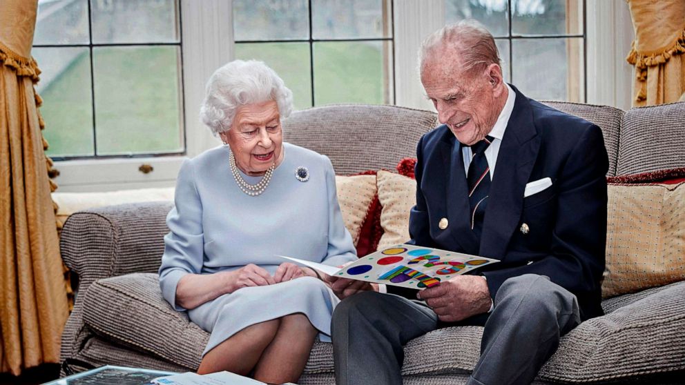 PHOTO: Britain's Queen Elizabeth and Prince Philip, Duke of Edinburgh look at their homemade wedding anniversary card in the Oak Room at Windsor Castle, Windsor, Britain, Nov. 17, 2020. 