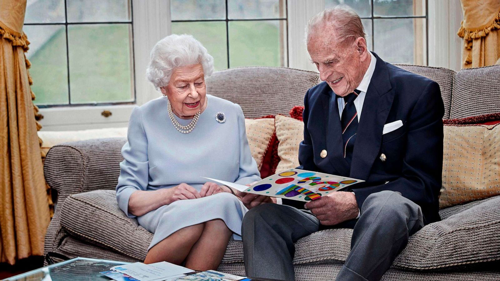 PHOTO: Britain's Queen Elizabeth and Prince Philip, Duke of Edinburgh look at their homemade wedding anniversary card in the Oak Room at Windsor Castle, Windsor, Britain, Nov. 17, 2020.