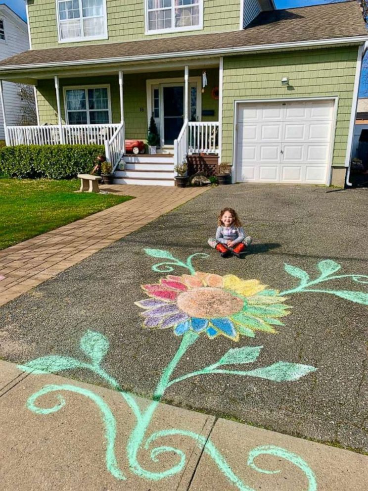 PHOTO: Violet, 4, sits in front of her Long Island home beside a rainbow flower created to spread hope amid the coronavirus crisis.