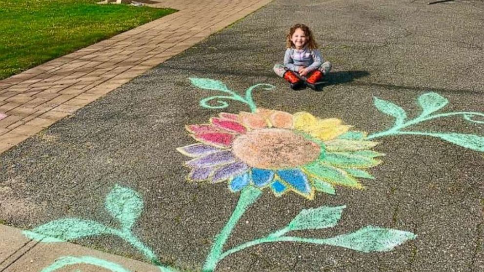 PHOTO: Violet, 4, sits in front of her Long Island home beside a rainbow flower created to spread hope amid the coronavirus crisis.