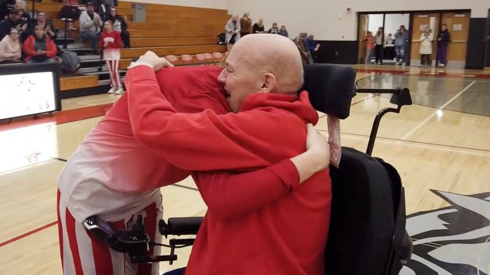 PHOTO: Randy Knecht greeted his daughter on the court after surprising her at Parent's Night at Cochrane-Fountaine City school in Fountain City, Wis.