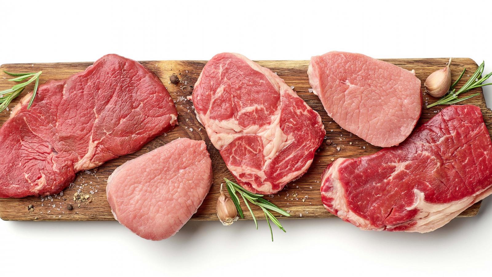 PHOTO: Various types of steak on wooden board isolated on white, from above