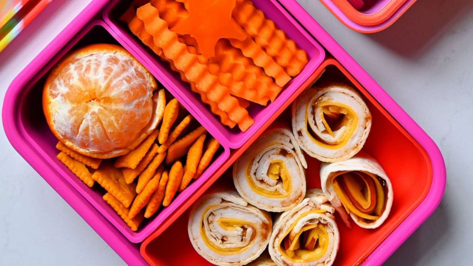 PHOTO: A kids' lunchbox with fun snacks and a red and orange color scheme.