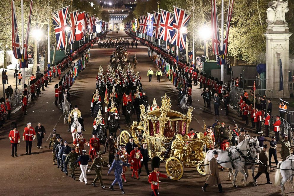 PHOTO: The Gold State Coach is accompanied by members of the military during a full overnight dress rehearsal ahead of the coronation for King Charles and Camilla, Queen Consort, in London, May 3, 2023.