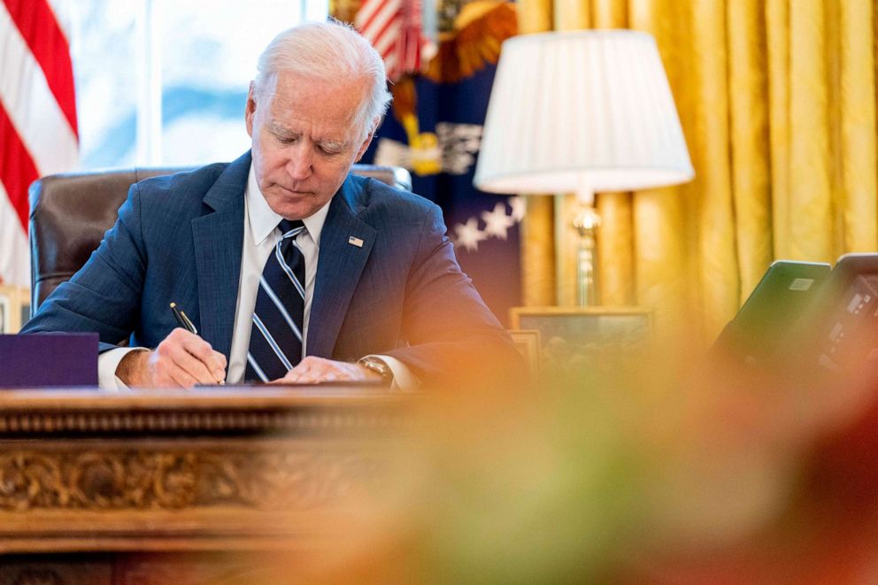 PHOTO: President Joe Biden signs the American Rescue Plan, a coronavirus relief package, in the Oval Office of the White House, , March 11, 2021.