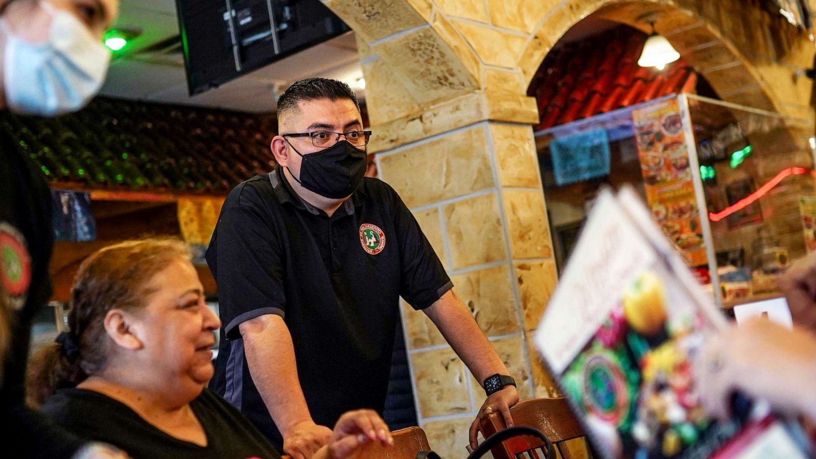 PHOTO: Chef and owner Alvaro Padilla and waitress Samantha Barba (left) talks with Carmen Lopezas she dines in with family at El Nacimiento in southwest Detroit, Feb. 26, 2021.