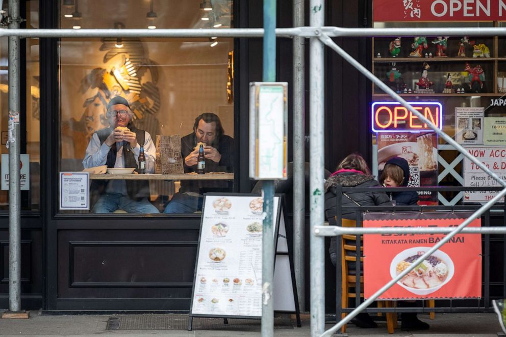 PHOTO: People sit a bar facing the street while dining indoors near people dining outdoors at a restaurant next door on March 17, 2021, in New York.