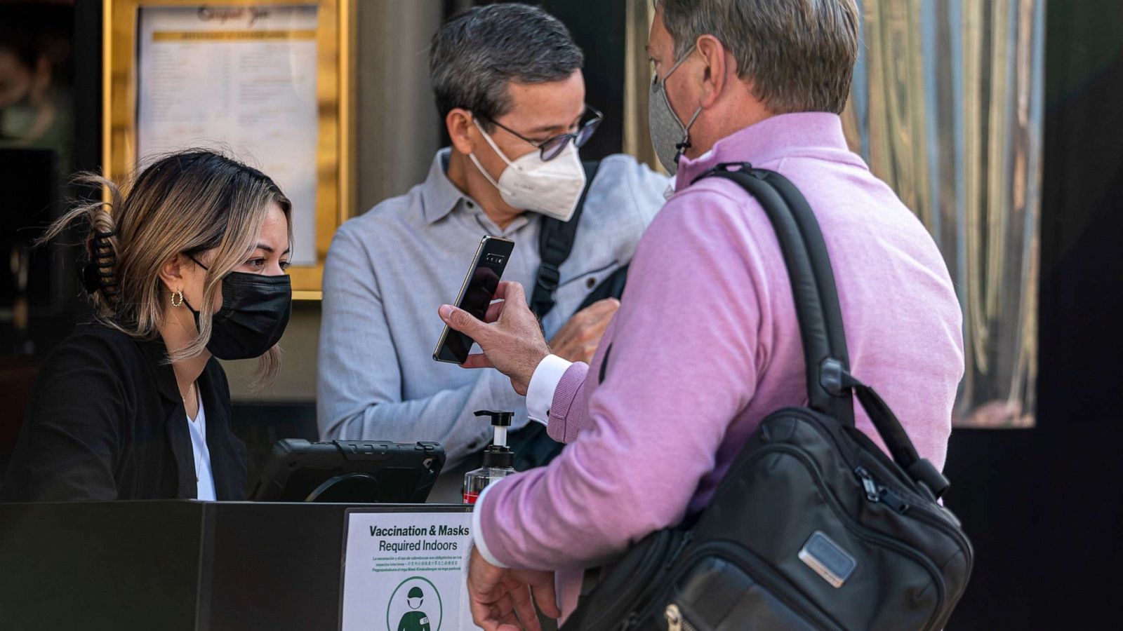 PHOTO: A customer shows proof of vaccination to a host at a restaurant in San Francisco, Aug. 24, 2021.