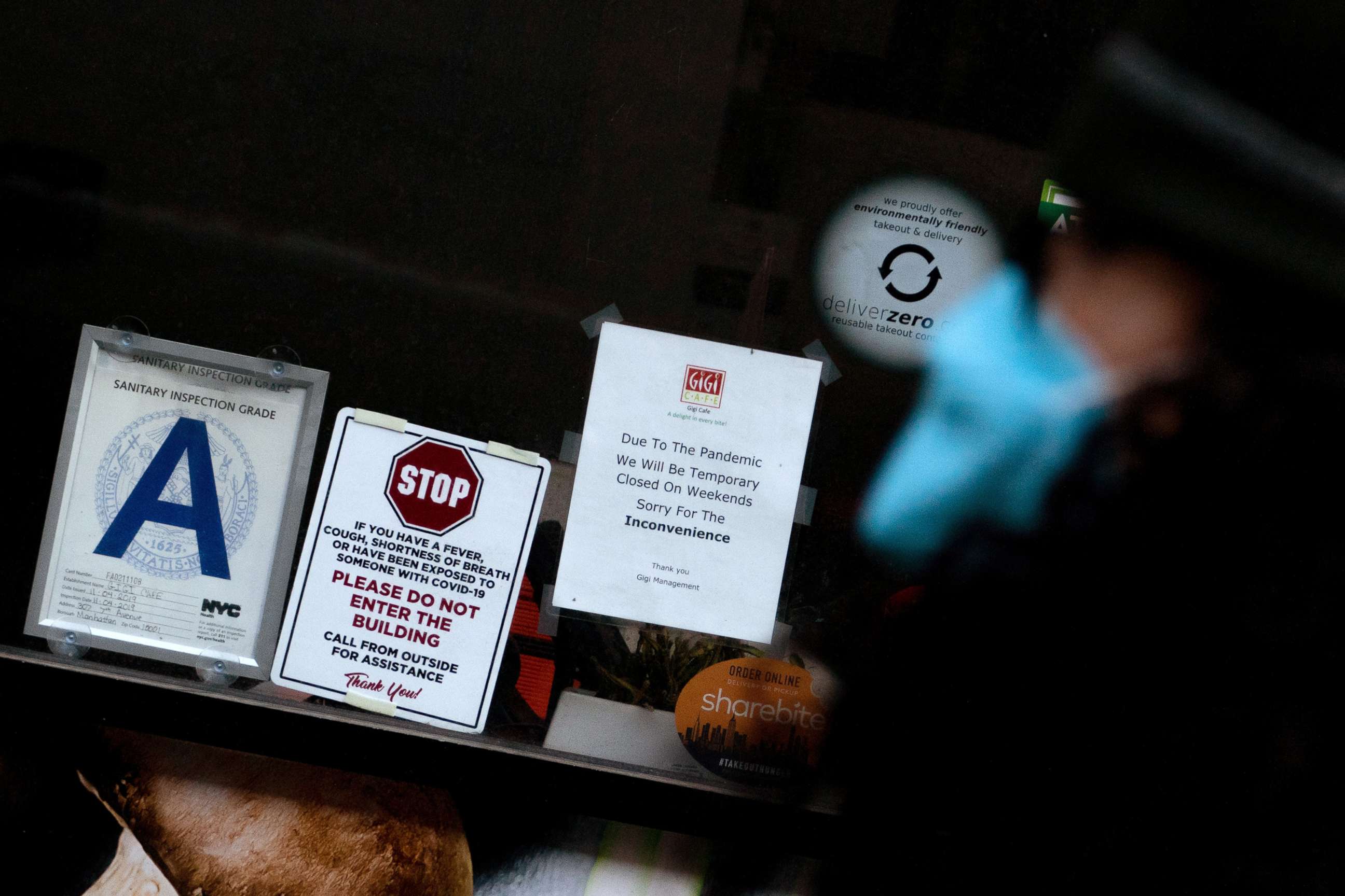 PHOTO: A person walks past a sign reading "Due to the pandemic, we will be closed on weekdays" displayed at a restaurant, Jan. 12, 2022, in New York City. 
