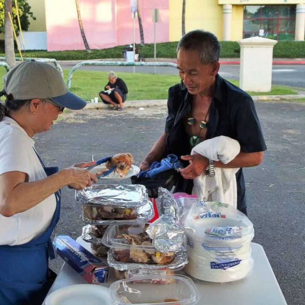 PHOTO: A Revive + Refresh volunteer serves a man hot food.