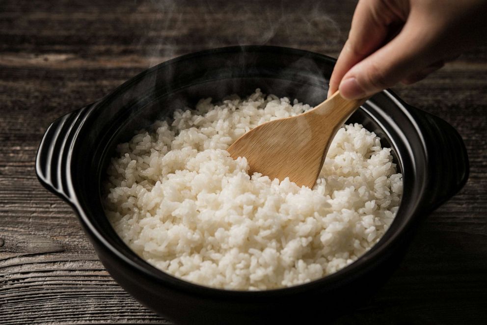 PHOTO: A steaming pot of rice is stirred.
