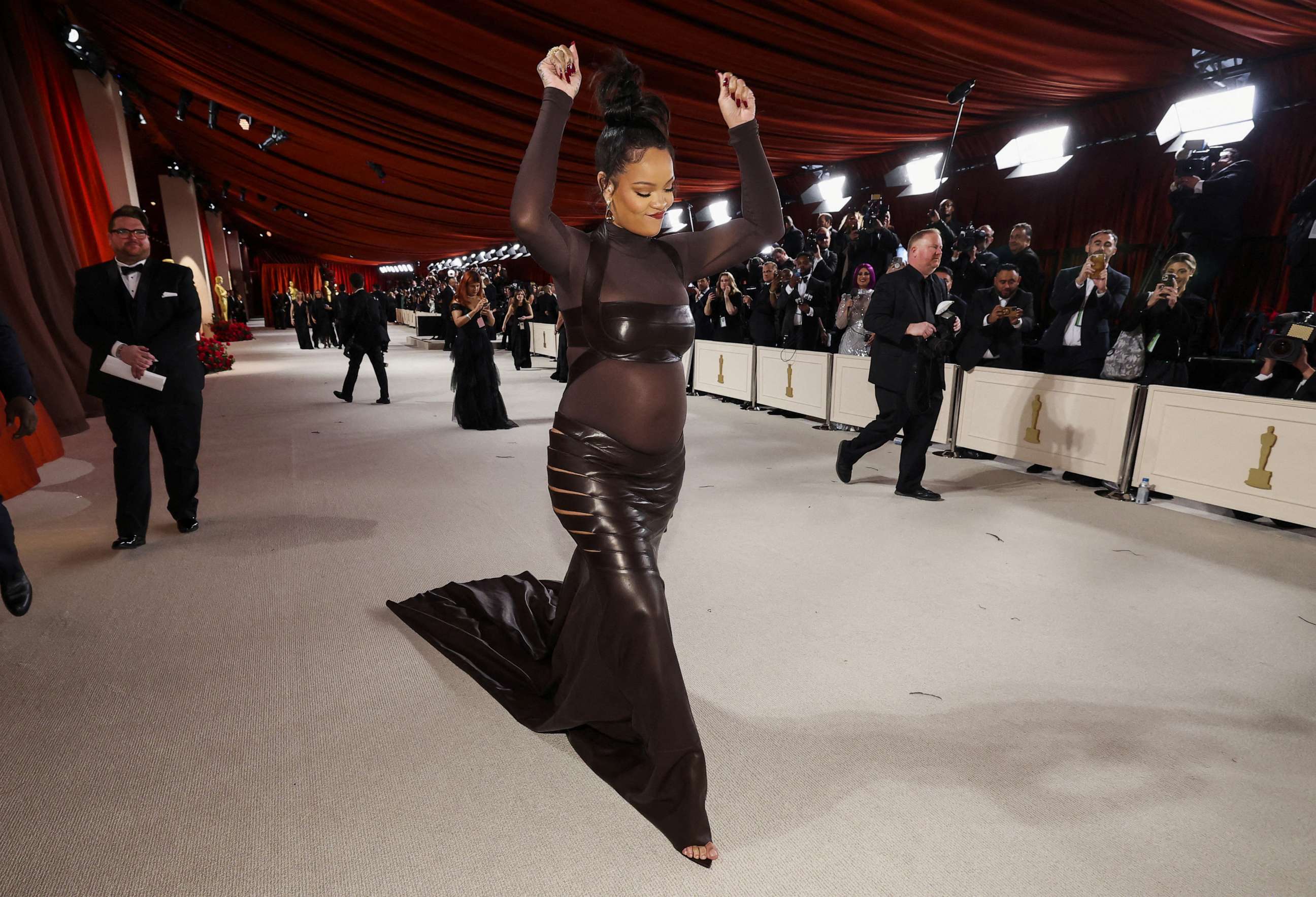 PHOTO: Rihanna, who is pregnant, gestures on the champagne-colored red carpet during the Oscars arrivals at the 95th Academy Awards in Hollywood, Los Angeles, March 12, 2023.