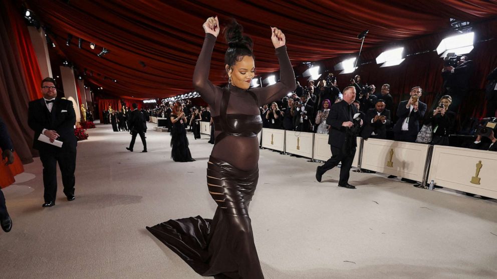 PHOTO: Rihanna, who is pregnant, gestures on the champagne-colored red carpet during the Oscars arrivals at the 95th Academy Awards in Hollywood, Los Angeles, March 12, 2023.