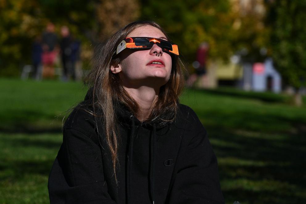 PHOTO: A spectator looks up at the sun using solar glasses during the Annular Solar Eclipse in Albuquerque, NM, Oct. 14, 2023.